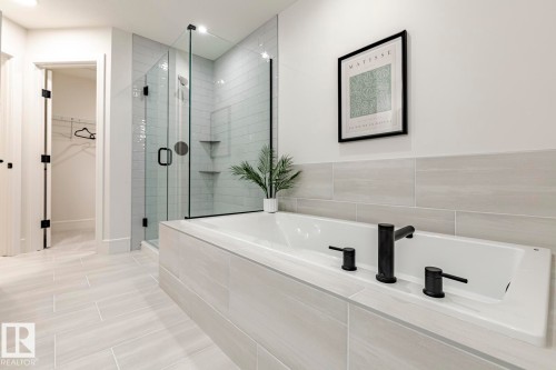 Full bathroom with a stall shower, a bath, and a walk in closet - 6275 180 Avenue, Edmonton, AB - Indoor Photo Showing Bathroom