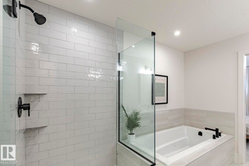Bathroom with a bath, a shower stall, ensuite bath, and recessed lighting - 6275 180 Avenue, Edmonton, AB - Indoor Photo Showing Bathroom
