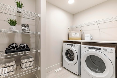 Laundry room with light tile patterned floors and separate washer and dryer - 6275 180 Avenue, Edmonton, AB - Indoor Photo Showing Laundry Room