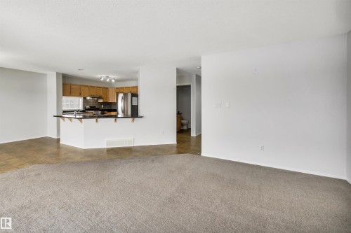 Unfurnished living room with dark colored carpet - 3401 47 Street, Beaumont, AB - Indoor