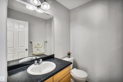 Half bath featuring vanity and toilet - 3401 47 Street, Beaumont, AB - Indoor Photo Showing Bathroom