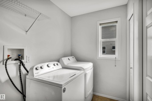 Laundry area with washing machine and clothes dryer and baseboards - 3401 47 Street, Beaumont, AB - Indoor Photo Showing Laundry Room