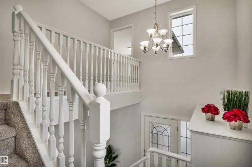 Stairway featuring a chandelier - 3401 47 Street, Beaumont, AB - Indoor Photo Showing Other Room