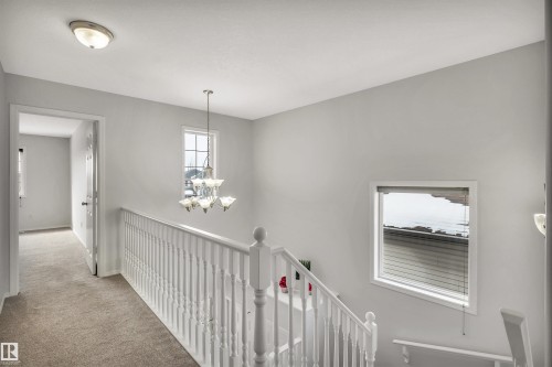 Hallway with an upstairs landing, a chandelier, and carpet - 3401 47 Street, Beaumont, AB - Indoor Photo Showing Other Room