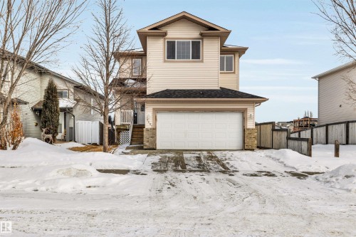 Traditional-style house with an attached garage, a gate, and roof with shingles - 3401 47 Street, Beaumont, AB - Outdoor