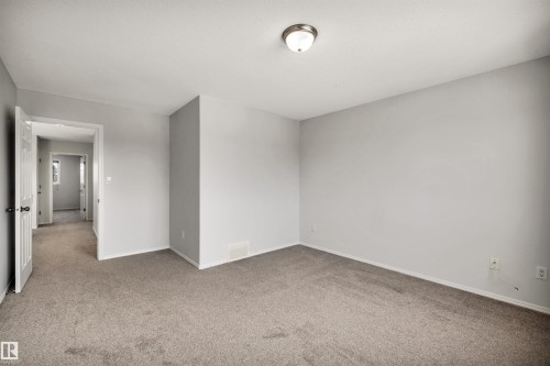 Carpeted spare room with baseboards - 3401 47 Street, Beaumont, AB - Indoor Photo Showing Other Room