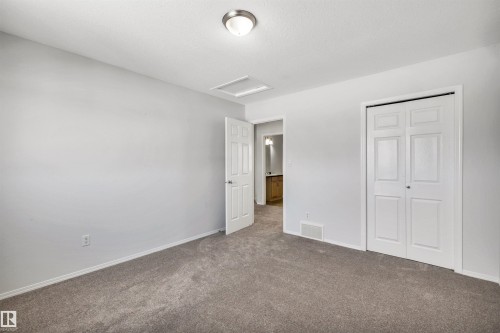 Unfurnished bedroom with dark carpet and a closet - 3401 47 Street, Beaumont, AB - Indoor Photo Showing Other Room