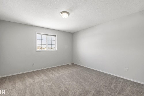 Empty room with carpet floors and a textured ceiling - 3401 47 Street, Beaumont, AB - Indoor Photo Showing Other Room