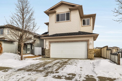 Traditional home with an attached garage, a gate, brick siding, and roof with shingles - 3401 47 Street, Beaumont, AB - Outdoor