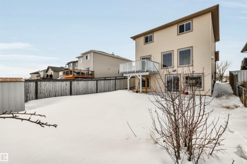 Snow covered rear of property with a fenced backyard, a patio area, a shed, and a residential view - 3401 47 Street, Beaumont, AB - Outdoor