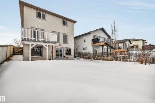 Snow covered property with a fenced backyard and a wooden deck - 3401 47 Street, Beaumont, AB - Outdoor