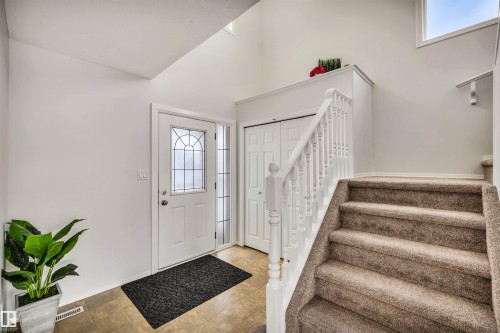 Foyer entrance featuring healthy amount of natural light, stone finish flooring, and a high ceiling - 3401 47 Street, Beaumont, AB - Indoor Photo Showing Other Room