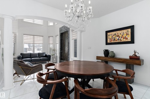 Dining space with ornate columns, arched walkways, hanging lights, light tile patterned floors, and a high ceiling - 1242 Starling Drive, Edmonton, AB - Indoor Photo Showing Dining Room