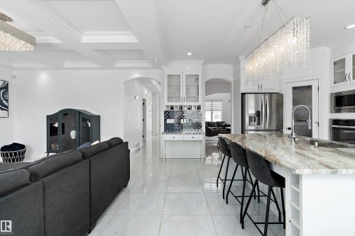 Living room featuring arched walkways, coffered ceiling, ornamental molding, and recessed lighting - 1242 Starling Drive, Edmonton, AB - Indoor Photo Showing Kitchen With Upgraded Kitchen
