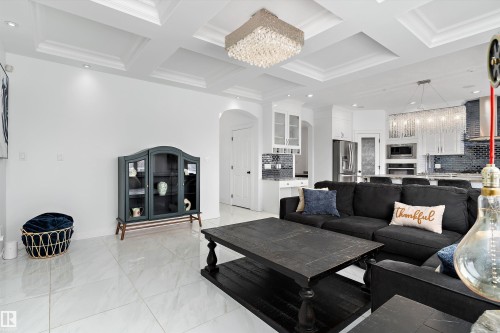 Living area with hanging lights, arched walkways, coffered ceiling, and crown molding - 1242 Starling Drive, Edmonton, AB - Indoor Photo Showing Living Room