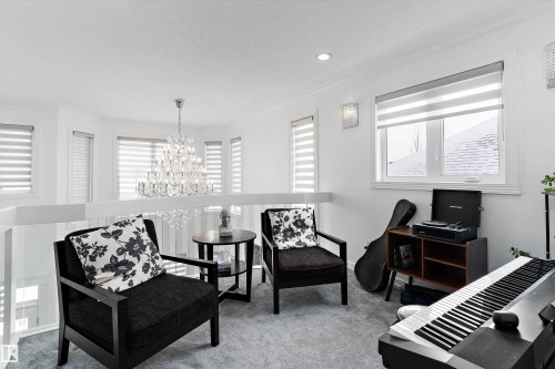 Living area featuring carpet flooring, a chandelier, plenty of natural light, and crown molding - 1242 Starling Drive, Edmonton, AB - Indoor
