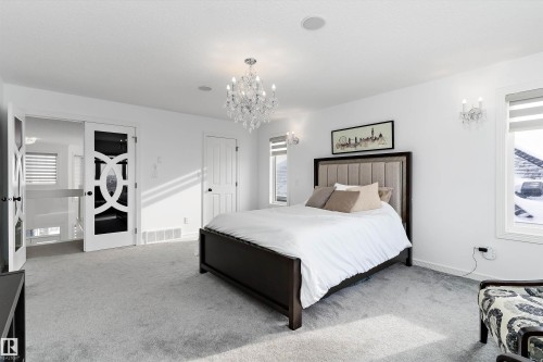 Carpeted bedroom featuring a chandelier and baseboards - 1242 Starling Drive, Edmonton, AB - Indoor Photo Showing Bedroom