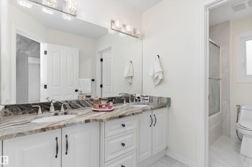 Full bath featuring double vanity and enclosed tub / shower combo - 1242 Starling Drive, Edmonton, AB - Indoor Photo Showing Bathroom