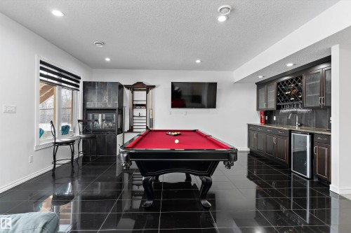 Game room featuring billiards table, beverage cooler, a multi sided fireplace, bar with sink, and recessed lighting - 1242 Starling Drive, Edmonton, AB - Indoor Photo Showing Other Room
