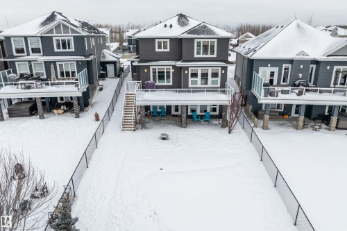 Snow covered property with a fenced backyard, a wooden deck, and a residential view - 1242 Starling Drive, Edmonton, AB - Outdoor With Deck Patio Veranda With Facade