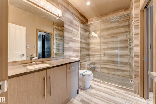 Bathroom featuring vanity, a shower stall, and tile walls - 102 10711 83 Avenue, Edmonton, AB - Indoor Photo Showing Bathroom