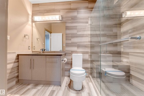 Bathroom with tile walls, vanity, and a shower stall - 102 10711 83 Avenue, Edmonton, AB - Indoor Photo Showing Bathroom