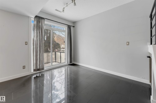 Empty room with rail lighting and dark tile patterned floors - 102 10711 83 Avenue, Edmonton, AB - Indoor Photo Showing Other Room