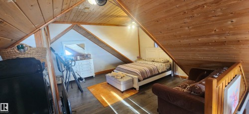 Bedroom featuring wooden ceiling, lofted ceiling, and dark wood finished floors - 5216 - 53 Avenue, Clyde, AB - Indoor