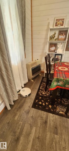 Detailed view of heating unit, wood finished floors, and wooden walls - 5216 - 53 Avenue, Clyde, AB - Indoor Photo Showing Other Room