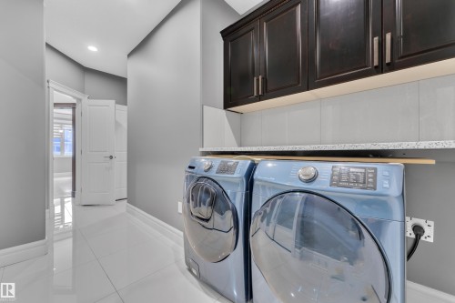 Laundry room with cabinet space, light tile patterned flooring, separate washer and dryer, and recessed lighting - 2612 Adam Court Sw, Edmonton, AB - Indoor Photo Showing Laundry Room