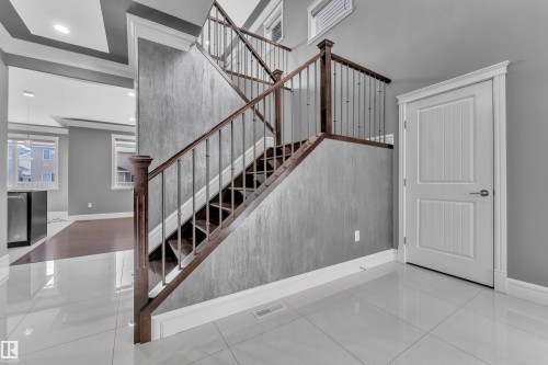 Stairway with tile patterned flooring, crown molding, an accent wall, and recessed lighting - 2612 Adam Court Sw, Edmonton, AB - Indoor Photo Showing Other Room