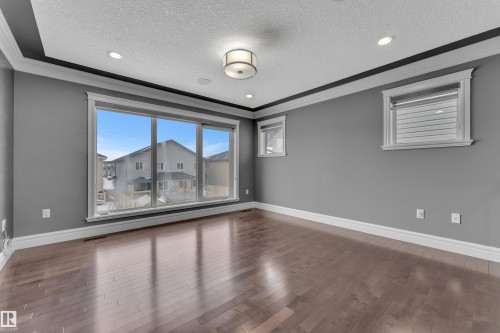 Unfurnished room with crown molding, a textured ceiling, dark wood finished floors, and recessed lighting - 2612 Adam Court Sw, Edmonton, AB - Indoor Photo Showing Other Room