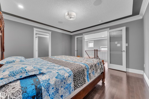 Bedroom featuring crown molding, dark wood-style floors, and a textured ceiling - 2612 Adam Court Sw, Edmonton, AB - Indoor Photo Showing Bedroom