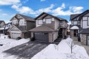 Craftsman house featuring asphalt driveway, a residential view, a garage, and stone siding - 2612 Adam Court Sw, Edmonton, AB  - Outdoor With Facade 
