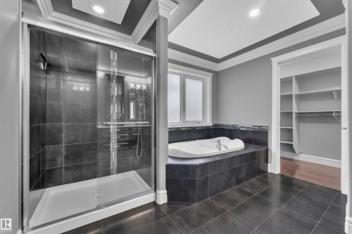 Full bathroom with dark tile patterned floors, ornamental molding, a stall shower, a garden tub, and recessed lighting - 2612 Adam Court Sw, Edmonton, AB - Indoor Photo Showing Bathroom