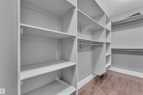 Walk in closet featuring dark wood-style flooring - 2612 Adam Court Sw, Edmonton, AB - Indoor With Storage
