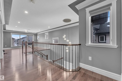 Hall with an upstairs landing, crown molding, wood finished floors, and recessed lighting - 2612 Adam Court Sw, Edmonton, AB - Indoor Photo Showing Other Room