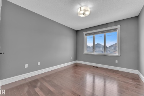 Empty room featuring hardwood / wood-style flooring and a textured ceiling - 2612 Adam Court Sw, Edmonton, AB - Indoor Photo Showing Other Room