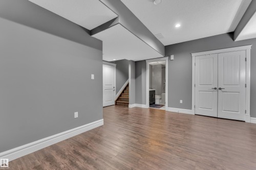 Finished basement featuring dark wood-style floors and recessed lighting - 2612 Adam Court Sw, Edmonton, AB - Indoor Photo Showing Other Room