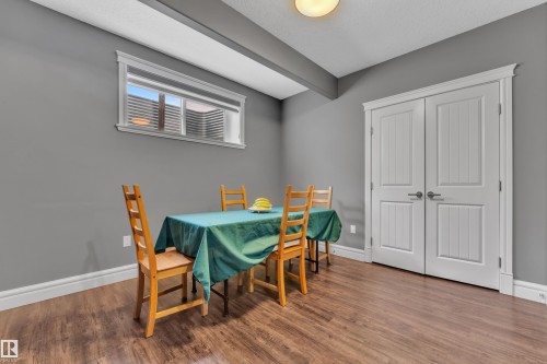 Dining space featuring wood finished floors, beamed ceiling, and a textured ceiling - 2612 Adam Court Sw, Edmonton, AB - Indoor