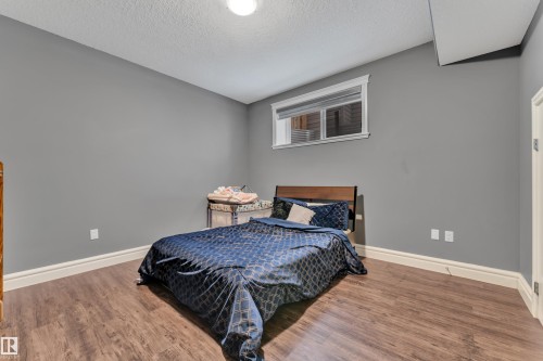 Bedroom with wood finished floors and a textured ceiling - 2612 Adam Court Sw, Edmonton, AB - Indoor Photo Showing Bedroom