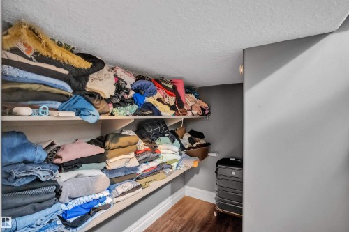 Walk in closet featuring dark wood-style flooring - 2612 Adam Court Sw, Edmonton, AB - Indoor