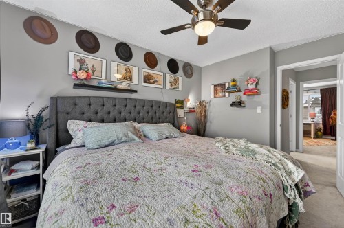 Bedroom featuring a textured ceiling, carpet flooring, and a ceiling fan - 14 1140 Chappelle Boulevard, Edmonton, AB - Indoor Photo Showing Bedroom