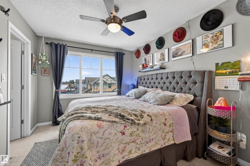 Bedroom with light carpet, a textured ceiling, and ceiling fan - 14 1140 Chappelle Boulevard, Edmonton, AB - Indoor Photo Showing Bedroom