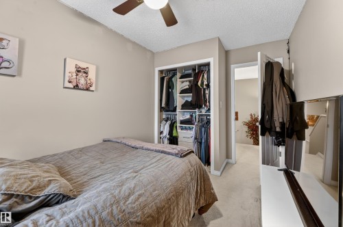 Bedroom featuring a textured ceiling, a closet, carpet flooring, and a ceiling fan - 14 1140 Chappelle Boulevard, Edmonton, AB - Indoor Photo Showing Bedroom
