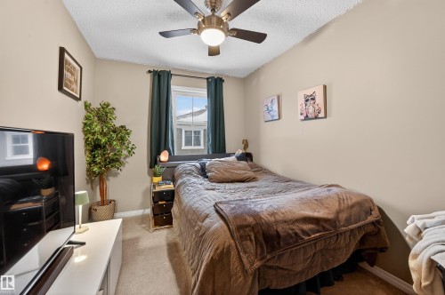 Bedroom featuring light carpet, a textured ceiling, and ceiling fan - 14 1140 Chappelle Boulevard, Edmonton, AB - Indoor Photo Showing Bedroom