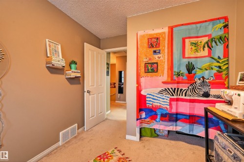Playroom with a textured ceiling and light colored carpet - 14 1140 Chappelle Boulevard, Edmonton, AB - Indoor Photo Showing Other Room
