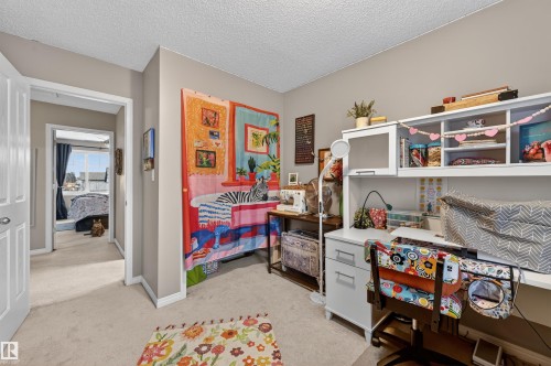 Bedroom with light colored carpet and a textured ceiling - 14 1140 Chappelle Boulevard, Edmonton, AB - Indoor