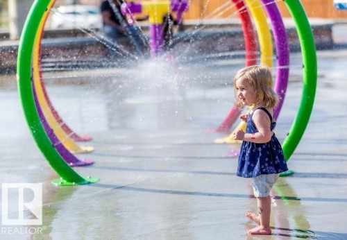 Community splash pad featuring colorful arched water features - 14 1140 Chappelle Boulevard, Edmonton, AB - Outdoor With Body Of Water