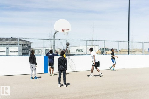 Community basketball court featuring a white backboard and chain-link fencing - 14 1140 Chappelle Boulevard, Edmonton, AB - 
